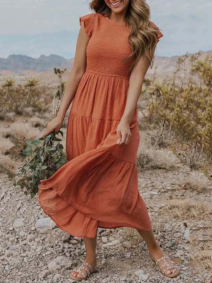 Women's sleeveless smocked midi dress with A-line skirt, airy fabric, perfect for summer occasions. Elegant and comfortable.