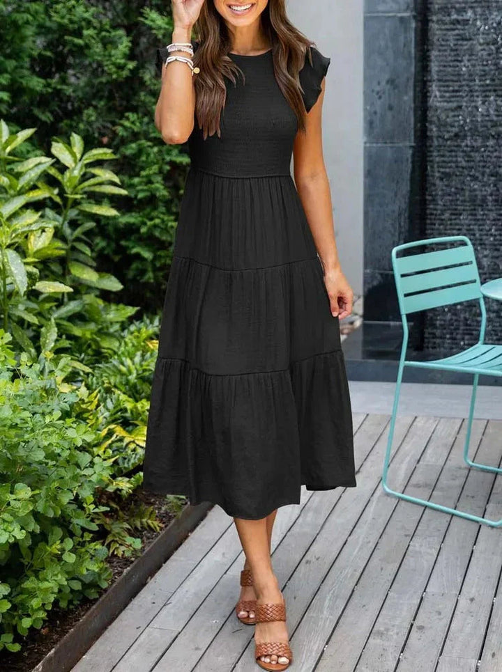 Women's sleeveless smocked midi dress with A-line skirt, airy fabric, perfect for summer occasions. Elegant and comfortable.