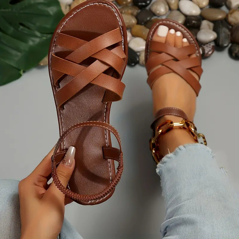 "Women's slip-on sandals with crisscross straps and elastic backband, perfect for comfort and style in casual outings."