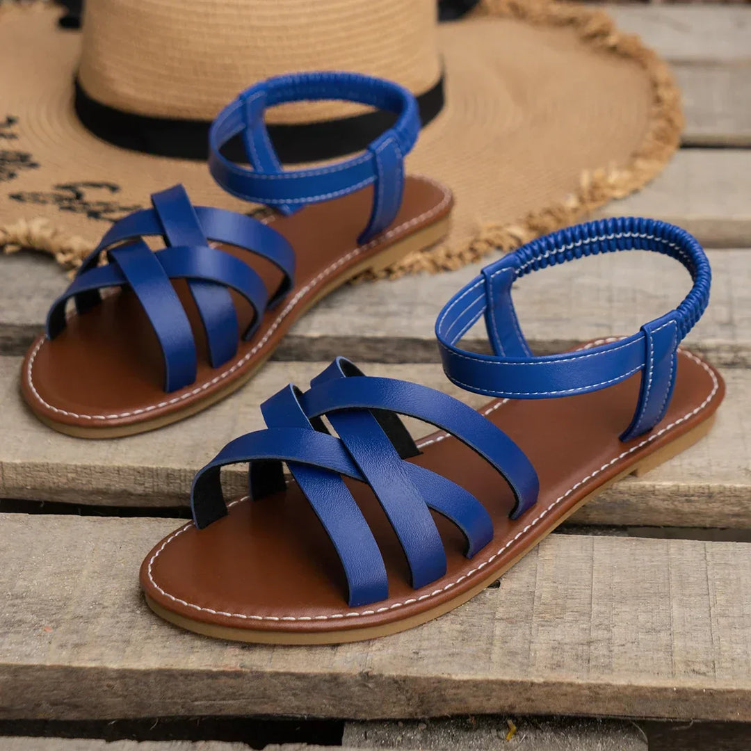 "Women's slip-on sandals with crisscross straps and elastic backband, perfect for comfort and style in casual outings."