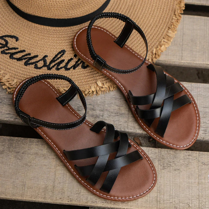 "Women's slip-on sandals with crisscross straps and elastic backband, perfect for comfort and style in casual outings."