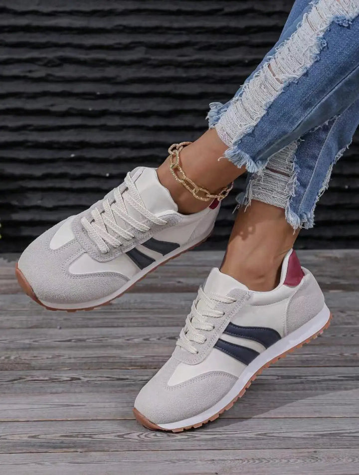 "Women's suede low top trainers with sleek suede upper, breathable fabric, and sporty side stripes for stylish comfort."