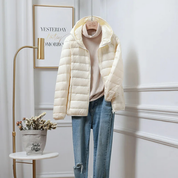 "Women's ultralight foldable puffer jacket with hood, chic design, lightweight, perfect for travel and cold weather."