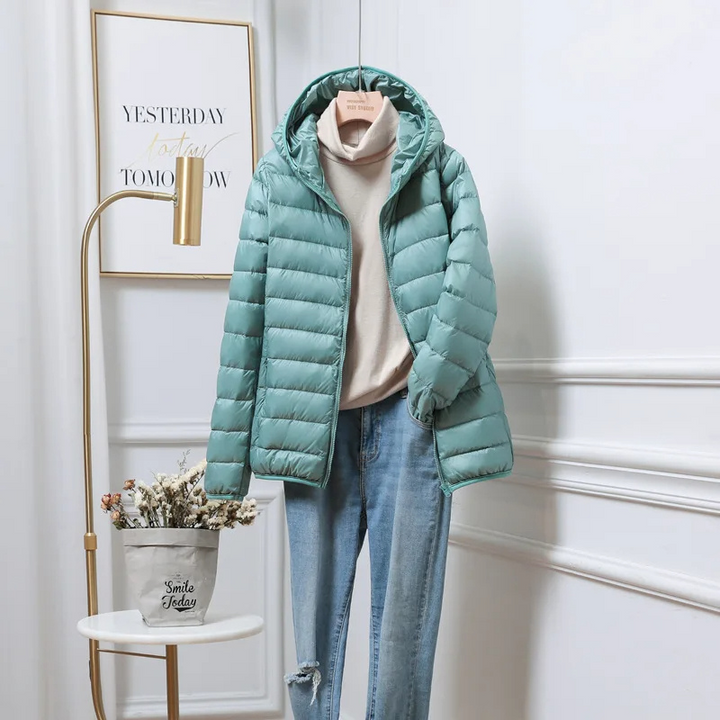 "Women's ultralight foldable puffer jacket with hood, chic design, lightweight, perfect for travel and cold weather."