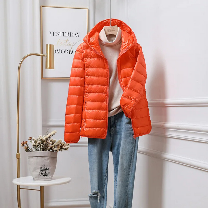 "Women's ultralight foldable puffer jacket with hood, chic design, lightweight, perfect for travel and cold weather."