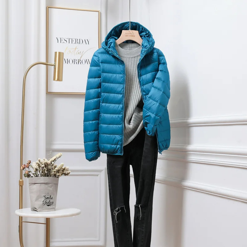 "Women's ultralight foldable puffer jacket with hood, chic design, lightweight, perfect for travel and cold weather."