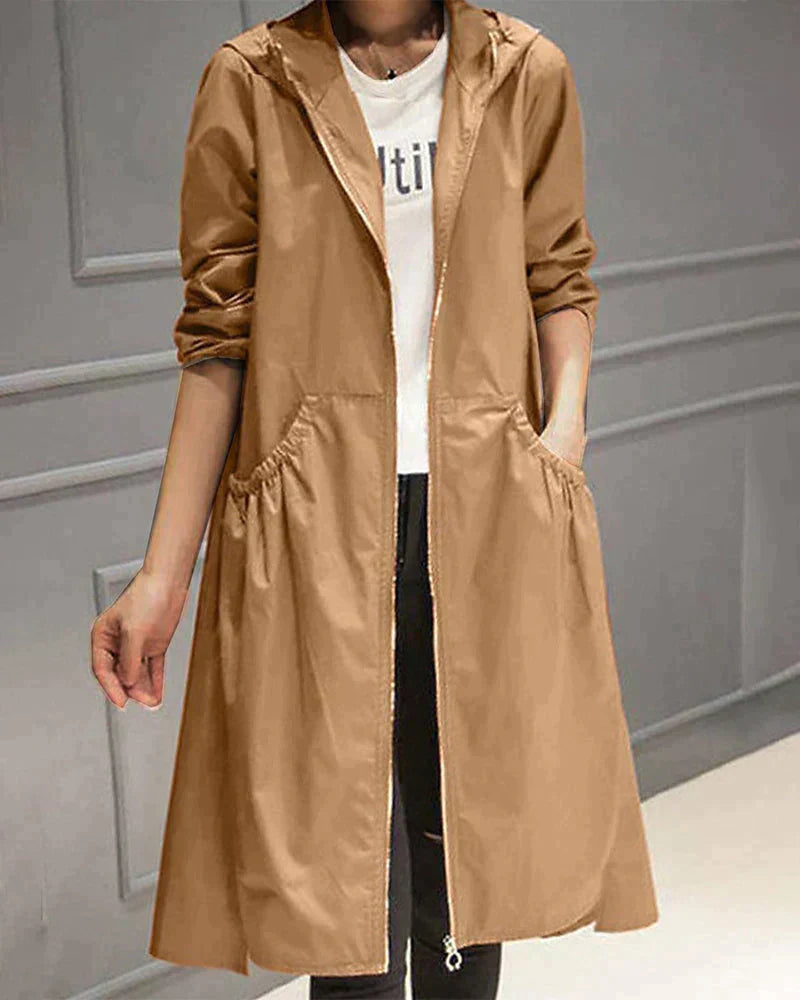 Women's waterproof hooded jacket in knee-length, relaxed fit, shown in lightweight fabric with ruched pockets for stylish cov