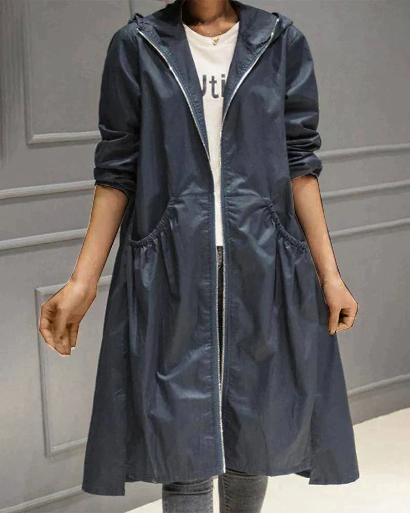 Women's waterproof hooded jacket in knee-length, relaxed fit, shown in lightweight fabric with ruched pockets for stylish cov