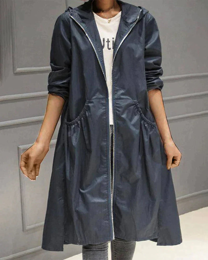 Women's waterproof hooded jacket in knee-length, relaxed fit, shown in lightweight fabric with ruched pockets for stylish cov