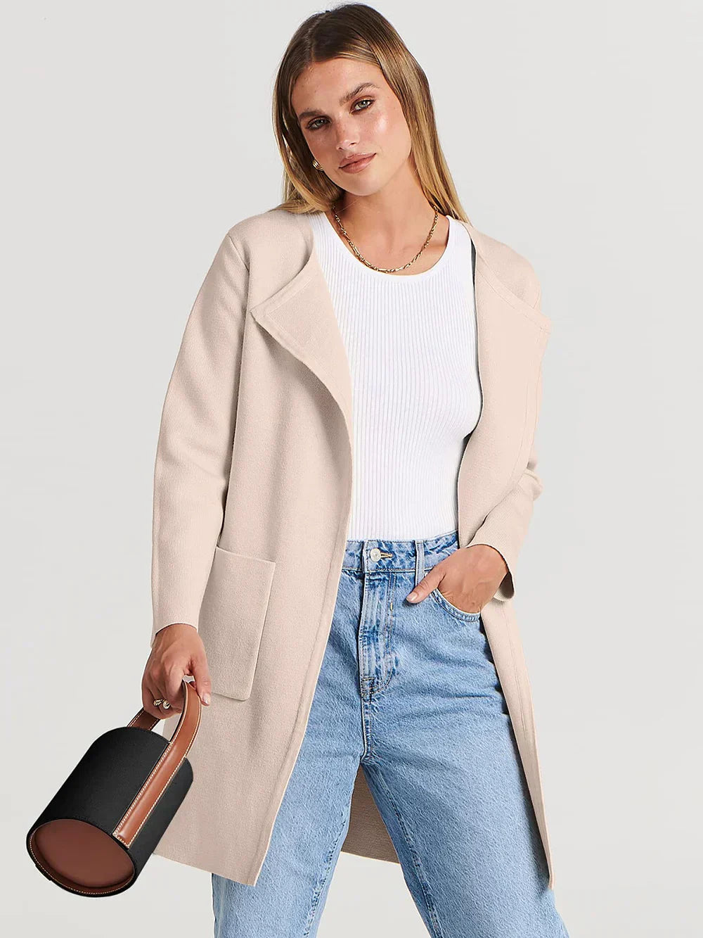 "Women's wool blend knee-length coat with wide lapel and patch pockets, showcasing a relaxed fit and minimalist design."