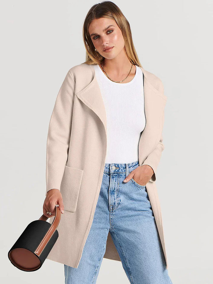 "Women's wool blend knee-length coat with wide lapel and patch pockets, showcasing a relaxed fit and minimalist design."