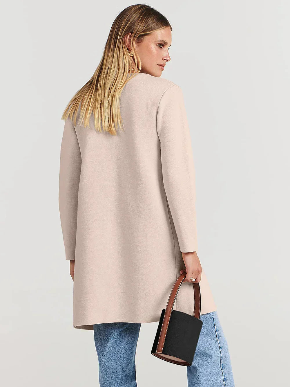 "Women's wool blend knee-length coat with wide lapel and patch pockets, showcasing a relaxed fit and minimalist design."