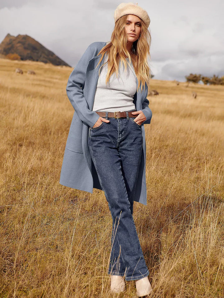 "Women's wool blend knee-length coat with wide lapel and patch pockets, showcasing a relaxed fit and minimalist design."