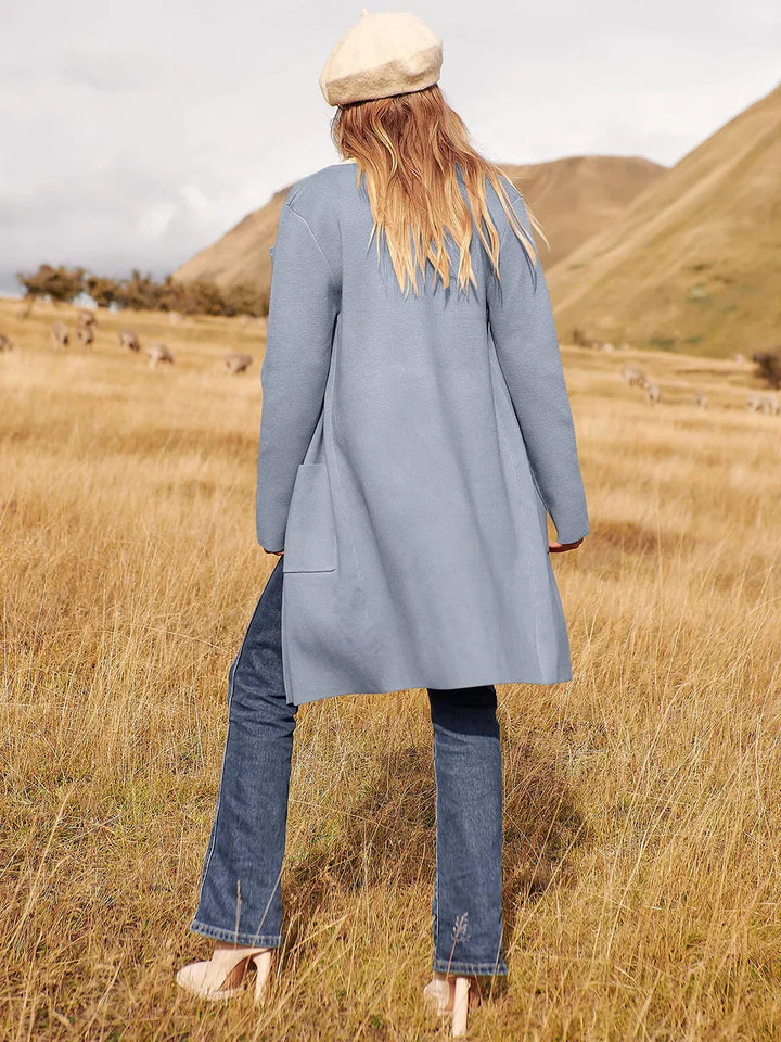 "Women's wool blend knee-length coat with wide lapel and patch pockets, showcasing a relaxed fit and minimalist design."