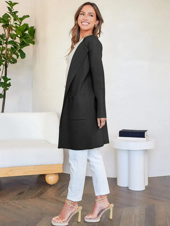 "Women's wool blend knee-length coat with wide lapel and patch pockets, showcasing a relaxed fit and minimalist design."