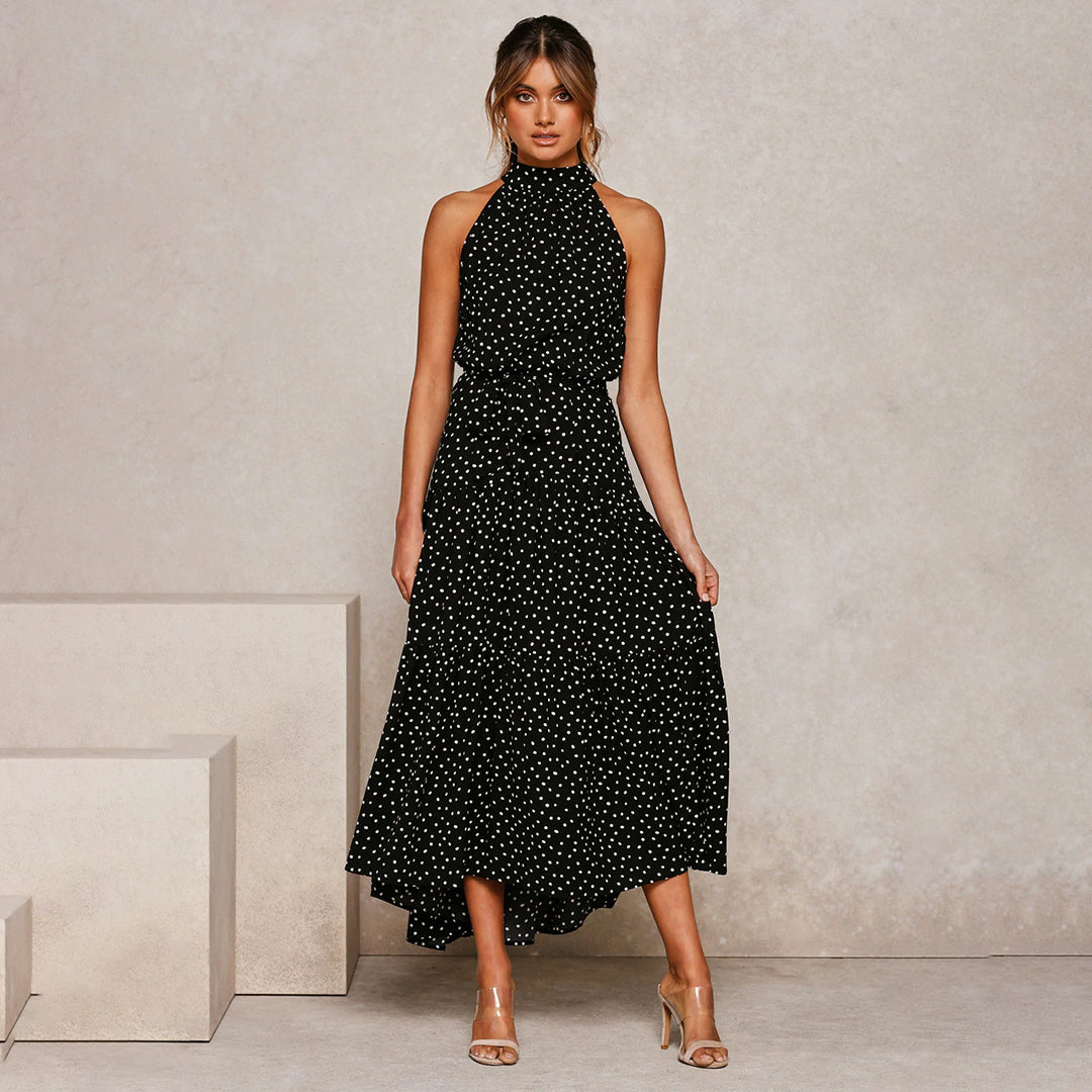 "Women's Yellow Polka Dot Halter Neck Maxi Dress with Tie Waist, featuring a tiered skirt for a flowing, elegant look."