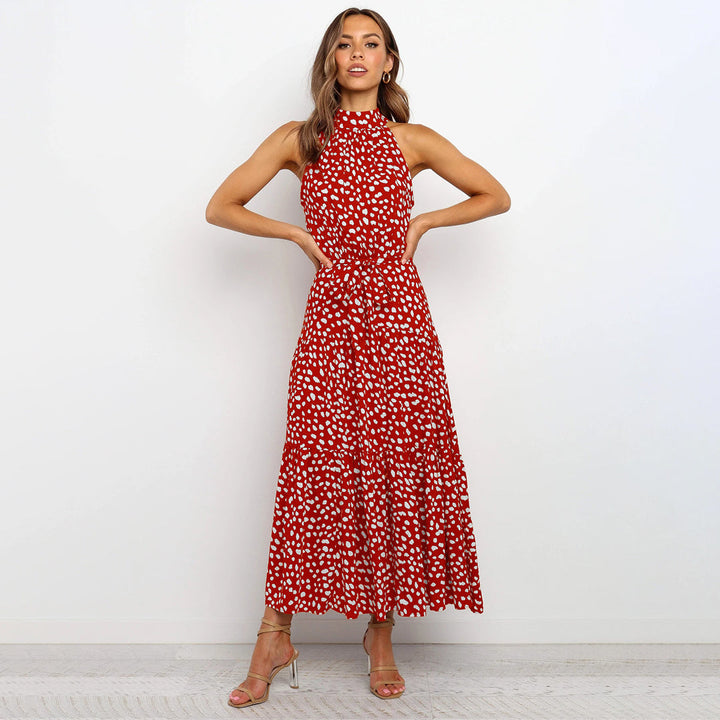 "Women's Yellow Polka Dot Halter Neck Maxi Dress with Tie Waist, featuring a tiered skirt for a flowing, elegant look."