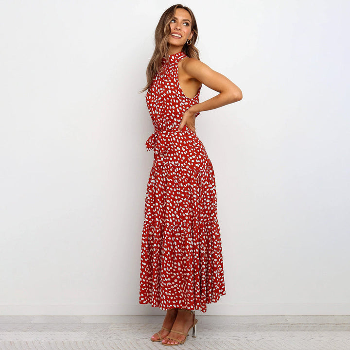 "Women's Yellow Polka Dot Halter Neck Maxi Dress with Tie Waist, featuring a tiered skirt for a flowing, elegant look."