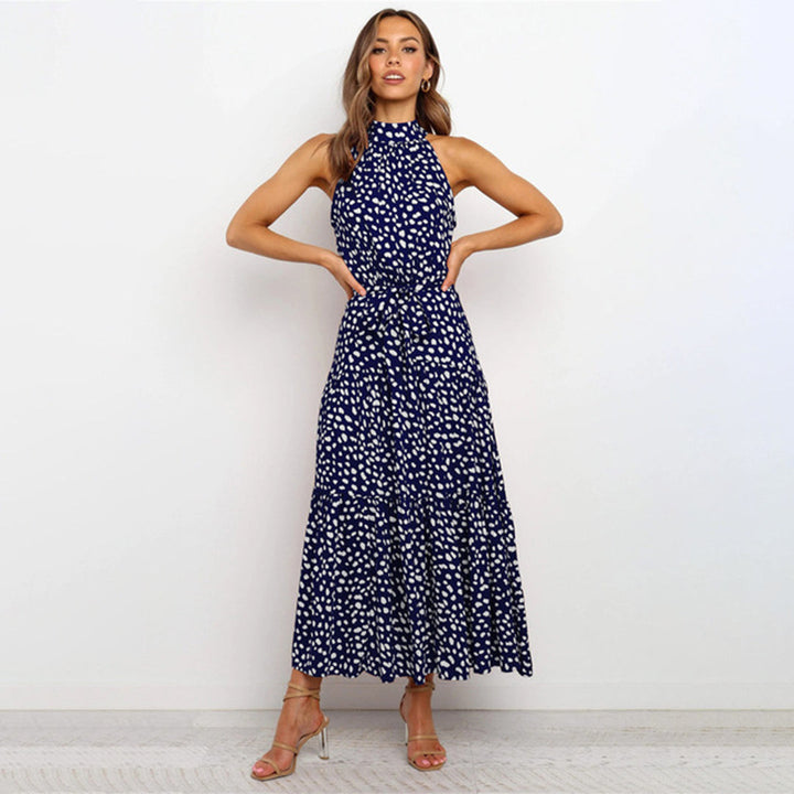 "Women's Yellow Polka Dot Halter Neck Maxi Dress with Tie Waist, featuring a tiered skirt for a flowing, elegant look."