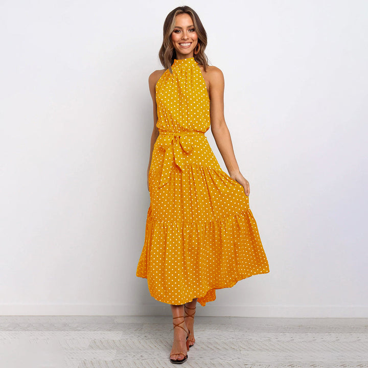 "Women's Yellow Polka Dot Halter Neck Maxi Dress with Tie Waist, featuring a tiered skirt for a flowing, elegant look."