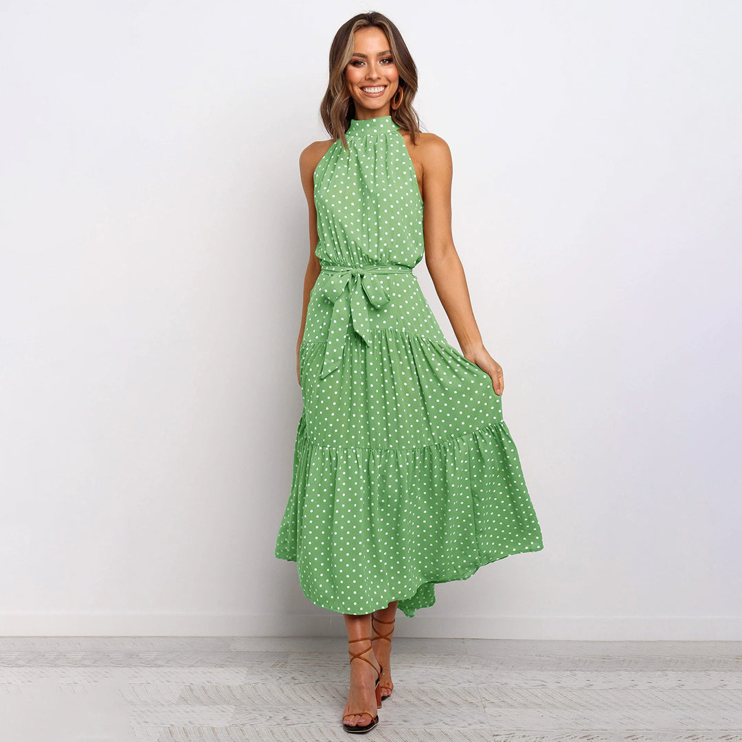 "Women's Yellow Polka Dot Halter Neck Maxi Dress with Tie Waist, featuring a tiered skirt for a flowing, elegant look."
