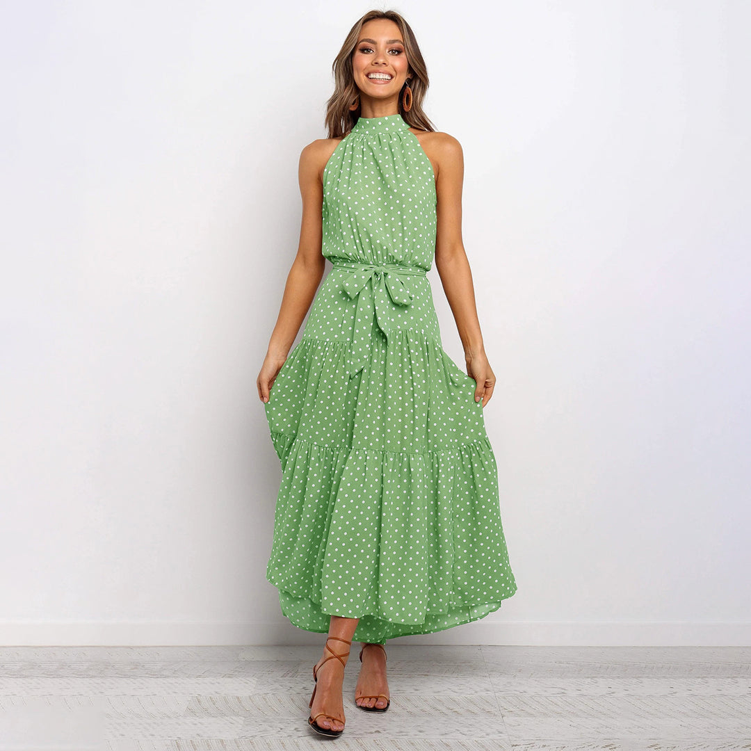 "Women's Yellow Polka Dot Halter Neck Maxi Dress with Tie Waist, featuring a tiered skirt for a flowing, elegant look."