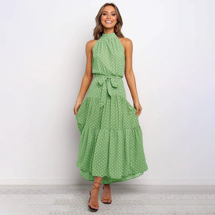 "Women's Yellow Polka Dot Halter Neck Maxi Dress with Tie Waist, featuring a tiered skirt for a flowing, elegant look."