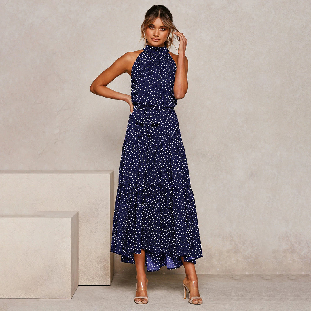 "Women's Yellow Polka Dot Halter Neck Maxi Dress with Tie Waist, featuring a tiered skirt for a flowing, elegant look."