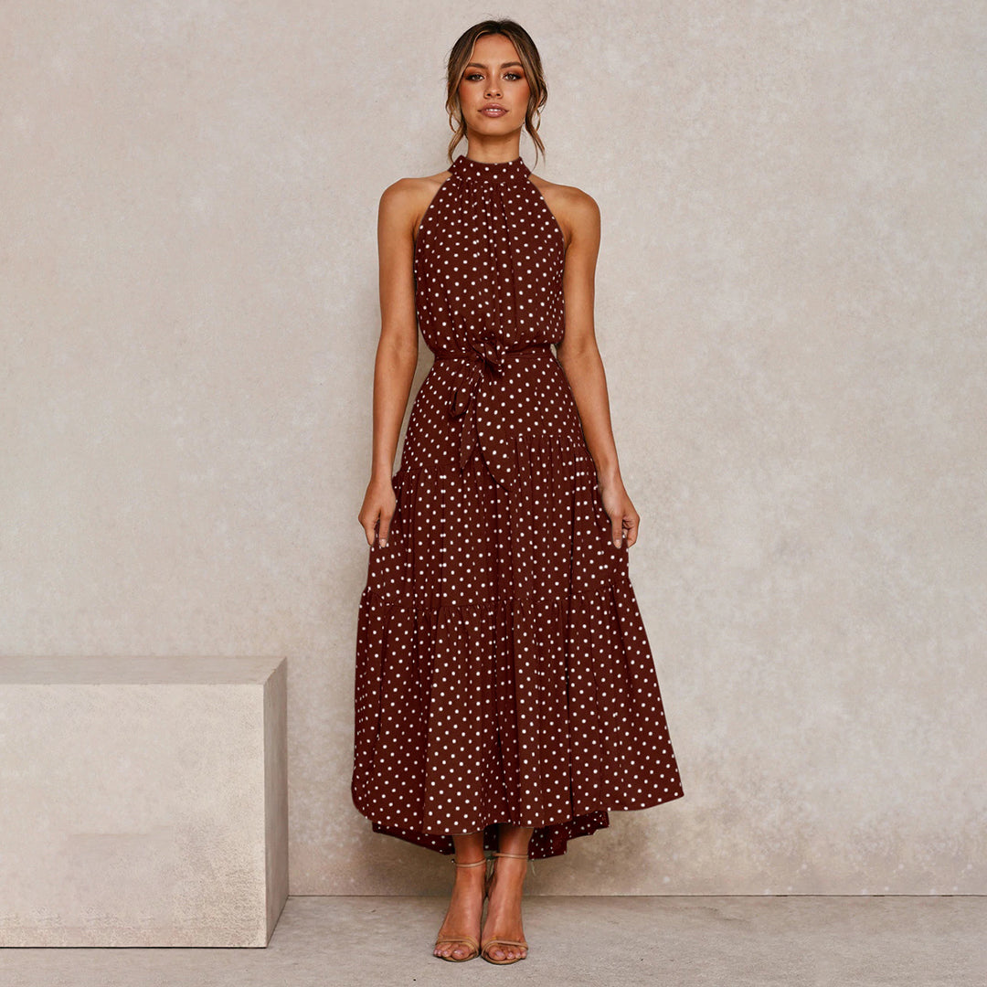 "Women's Yellow Polka Dot Halter Neck Maxi Dress with Tie Waist, featuring a tiered skirt for a flowing, elegant look."