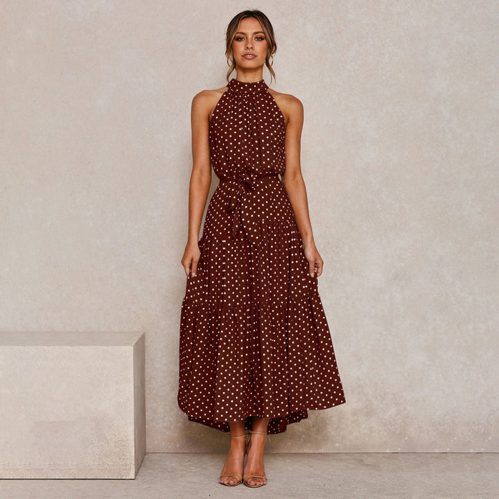 "Women's Yellow Polka Dot Halter Neck Maxi Dress with Tie Waist, featuring a tiered skirt for a flowing, elegant look."