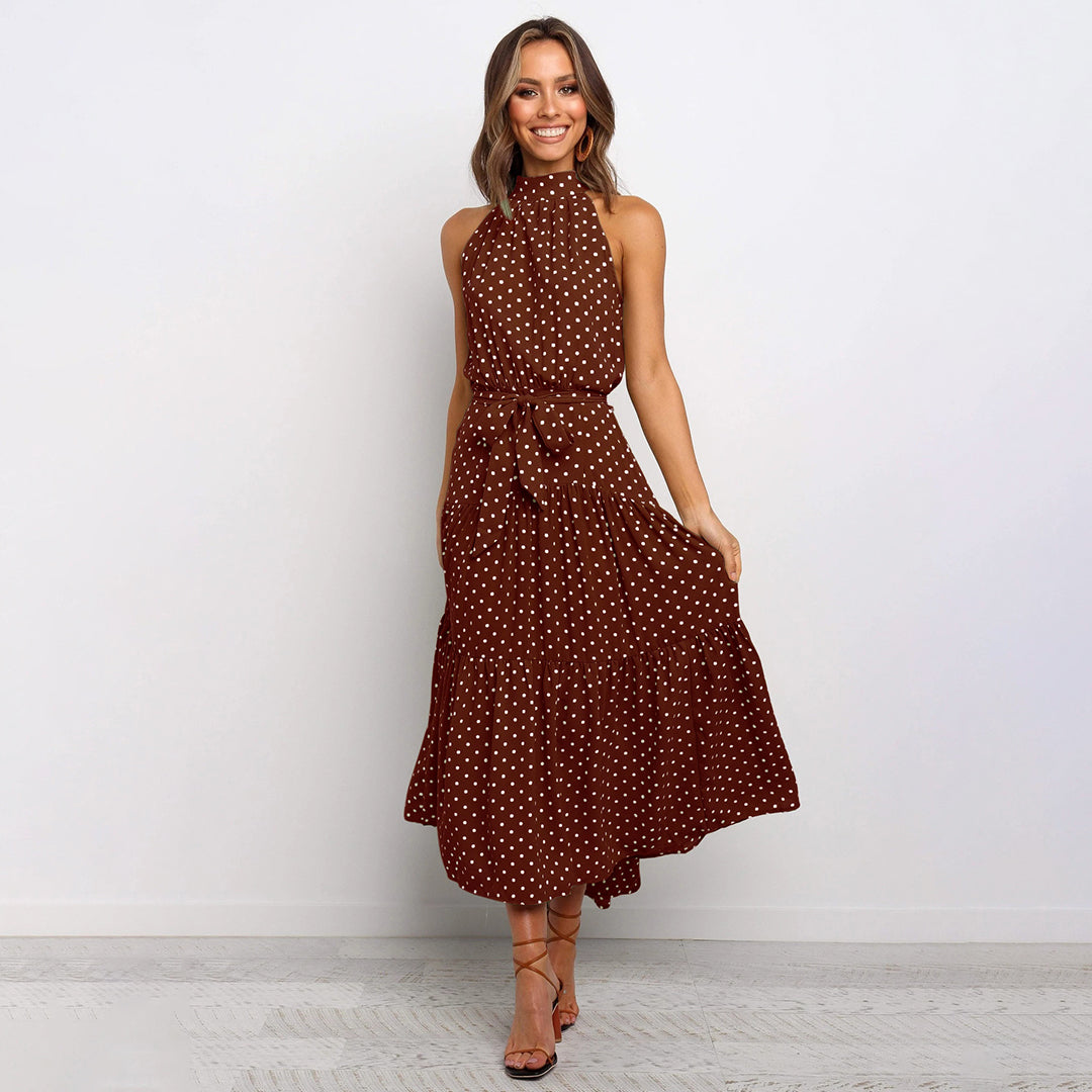 "Women's Yellow Polka Dot Halter Neck Maxi Dress with Tie Waist, featuring a tiered skirt for a flowing, elegant look."